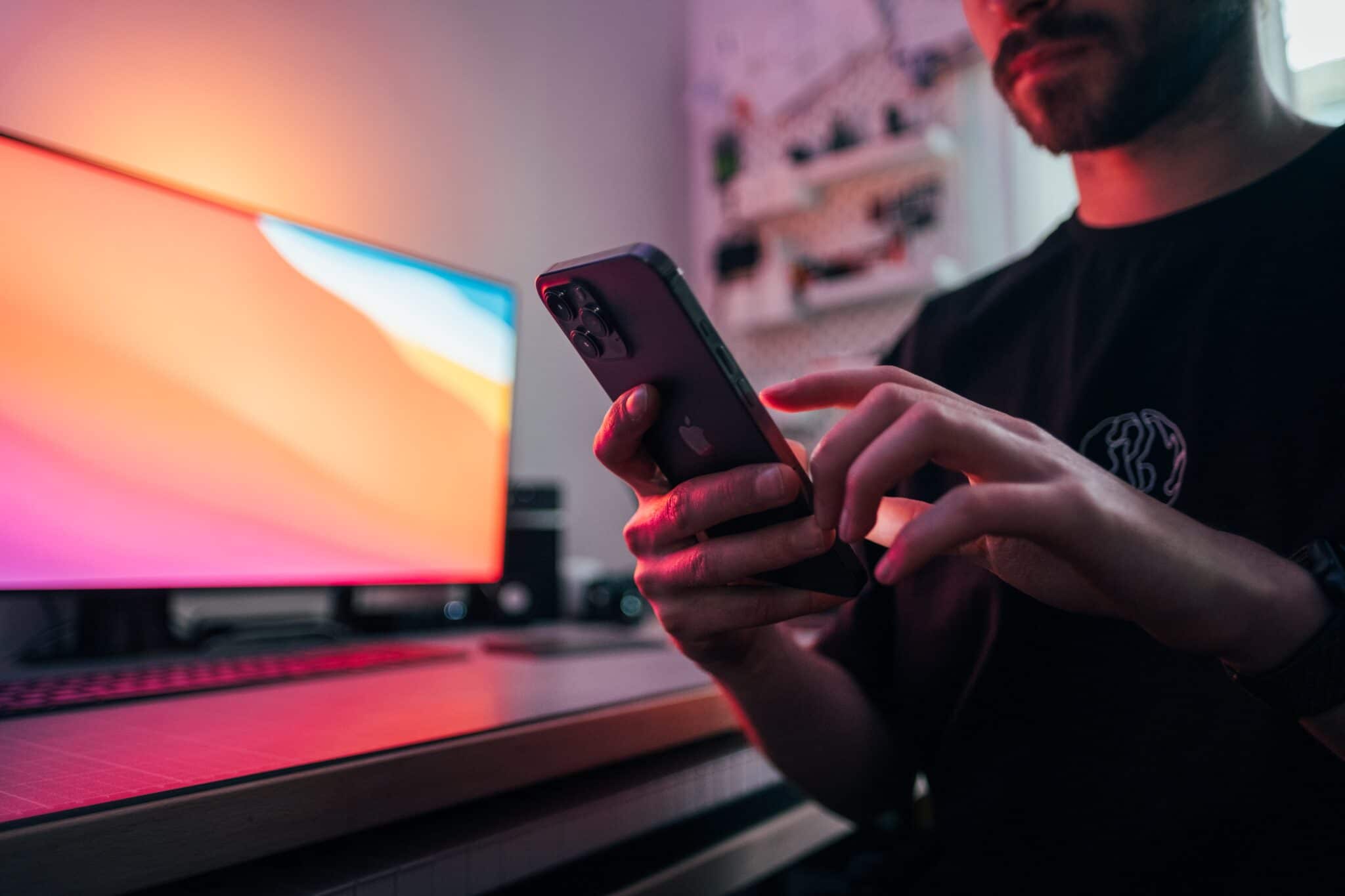 A bearded man is using an iPhone.